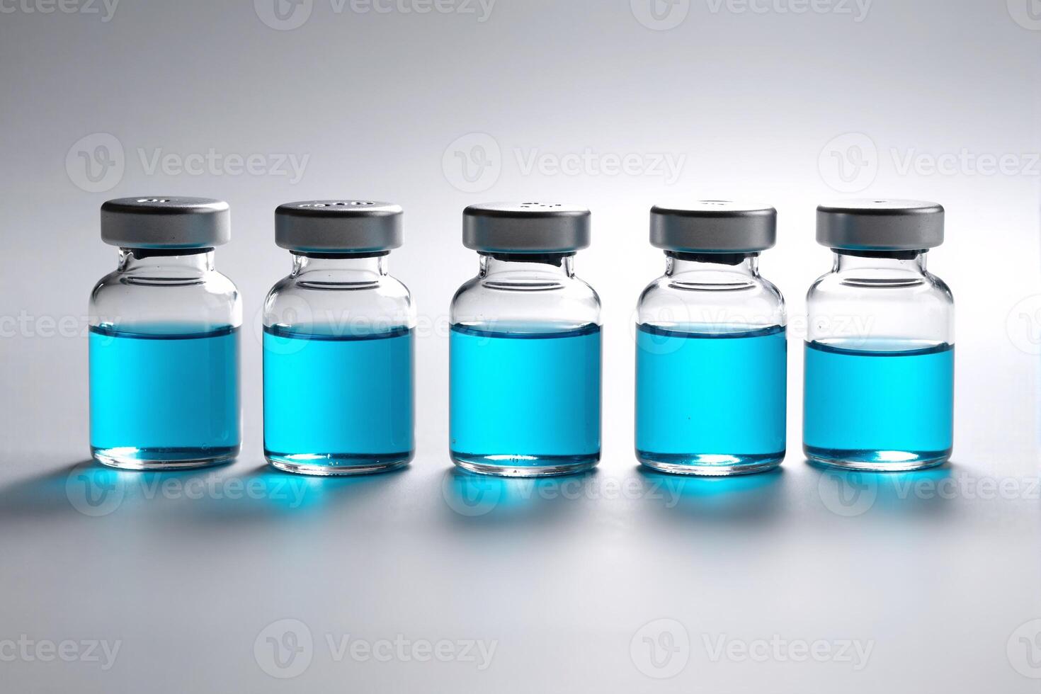 A group of blue liquid vials with a silver cap photo