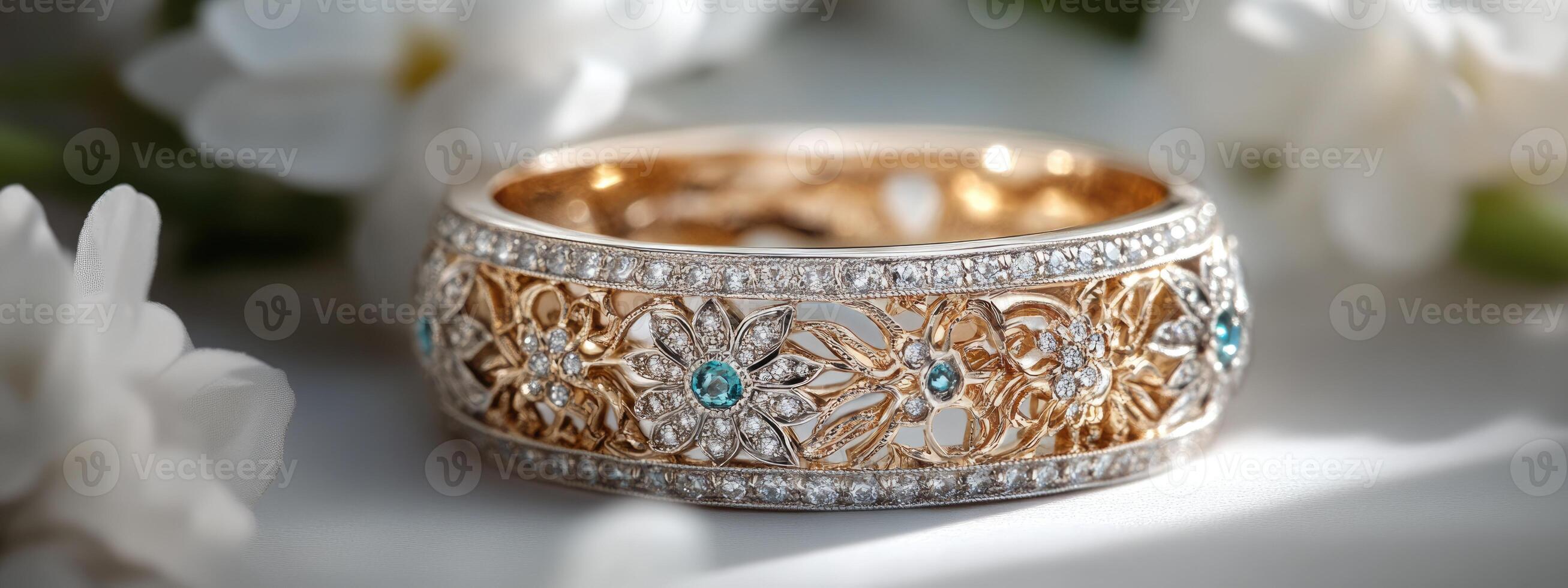 A stunning ring featuring intricate floral patterns and glimmering gemstones is showcased against a delicate arrangement of white flowers photo