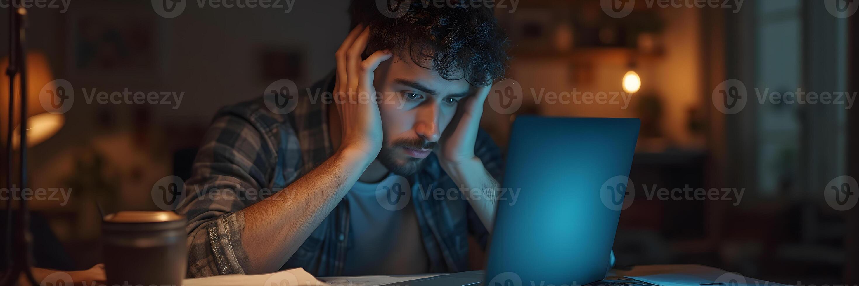 Stressed Man Working Late at Night on Laptop Computer photo