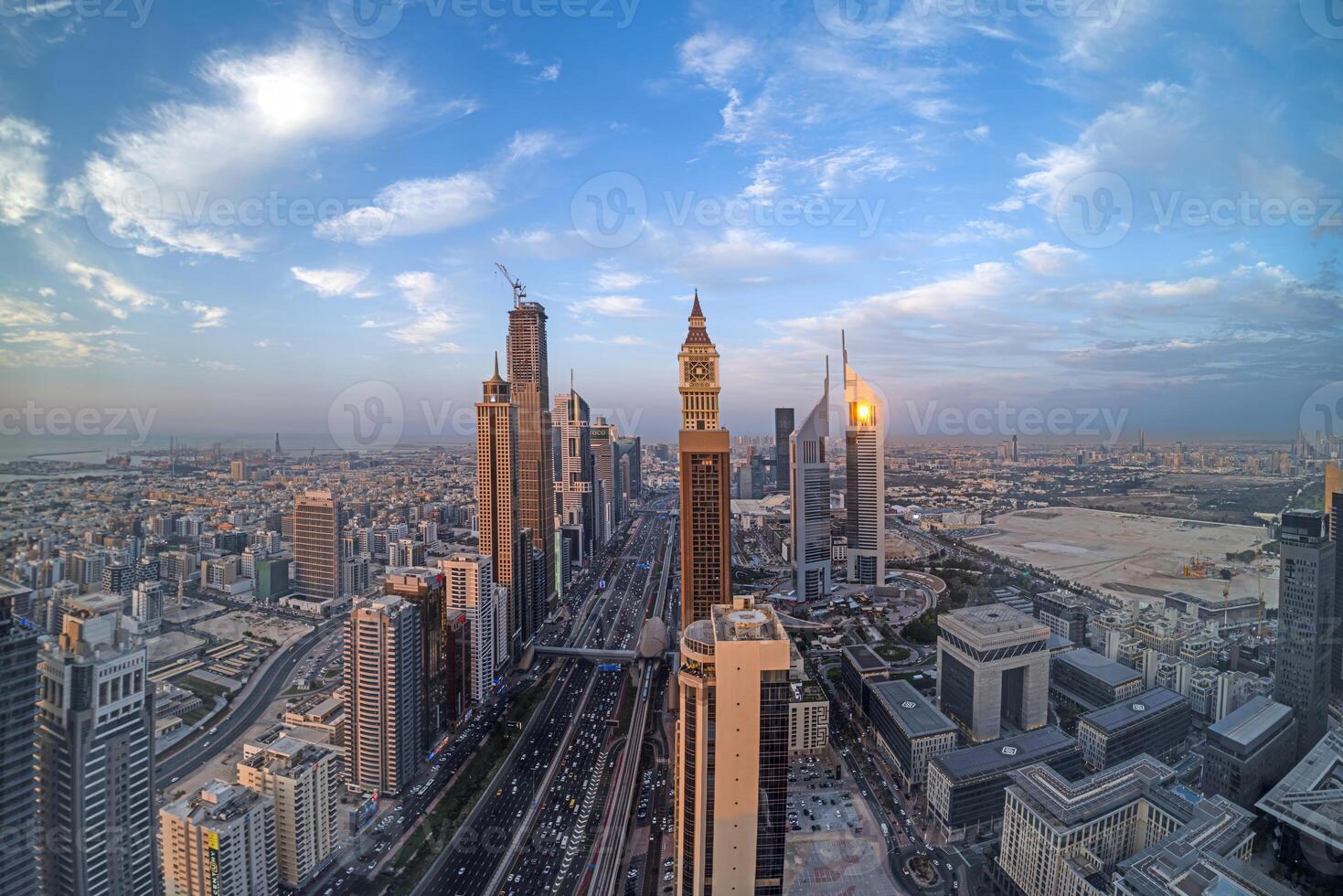 Aerial view of Sheikh Zayed Road in Dubai with skyscrapers and urban skyline under a blue sky photo