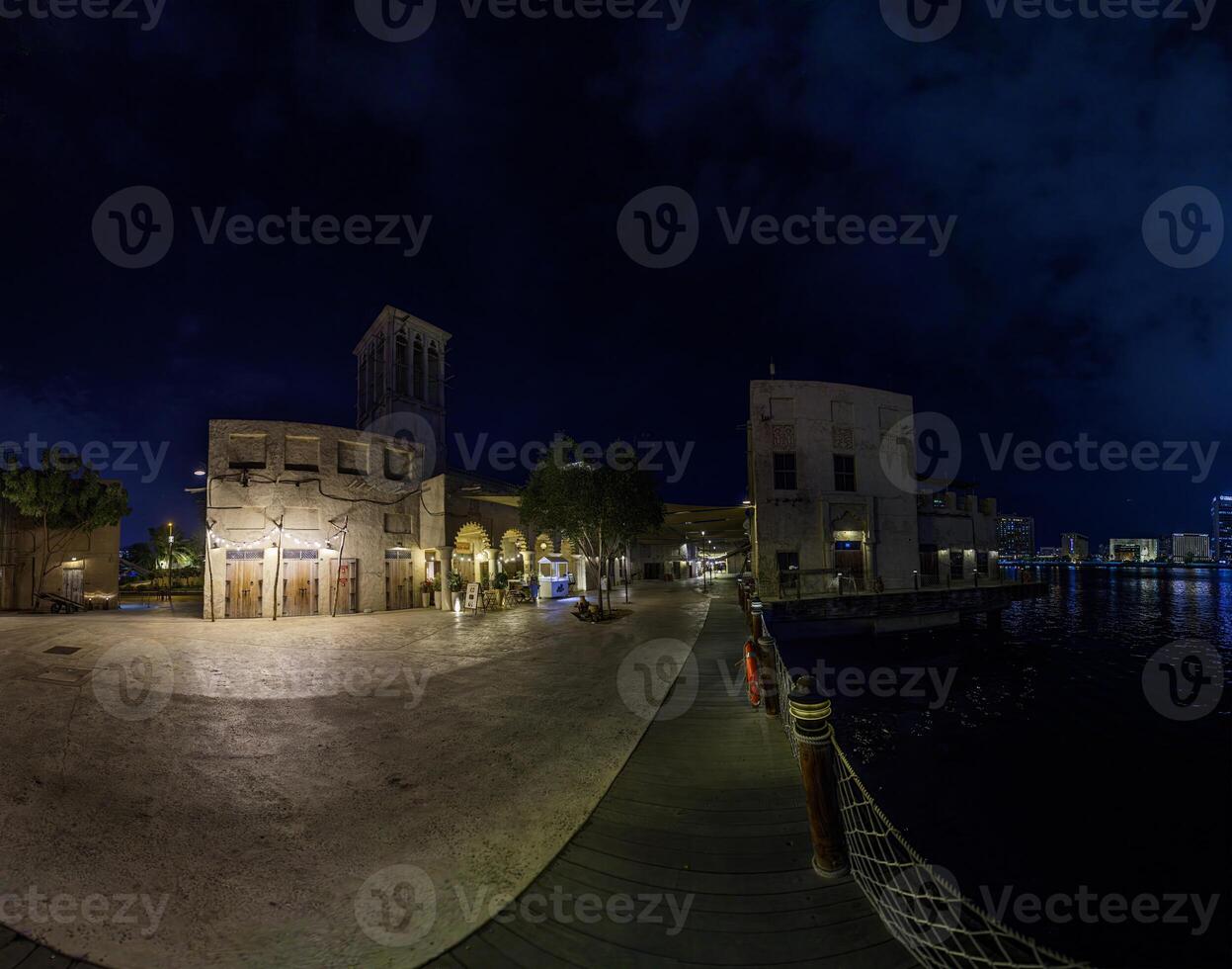 Historic souk at Dubai Creek at night with illuminated buildings and water reflections 1 photo