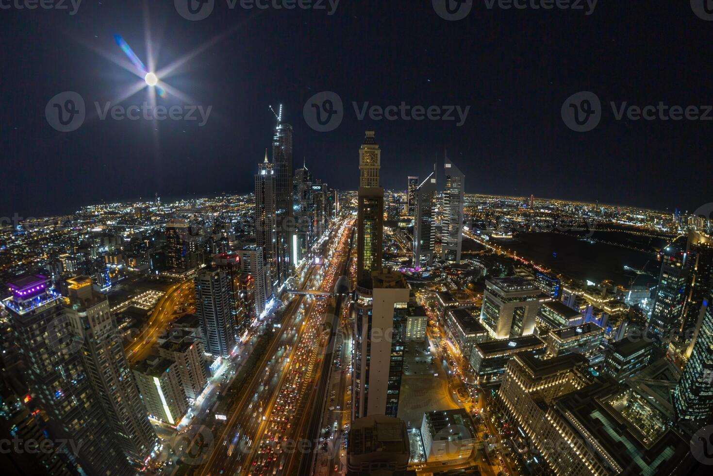 Sheikh Zayed Road illuminated at night under full moon in Dubai photo