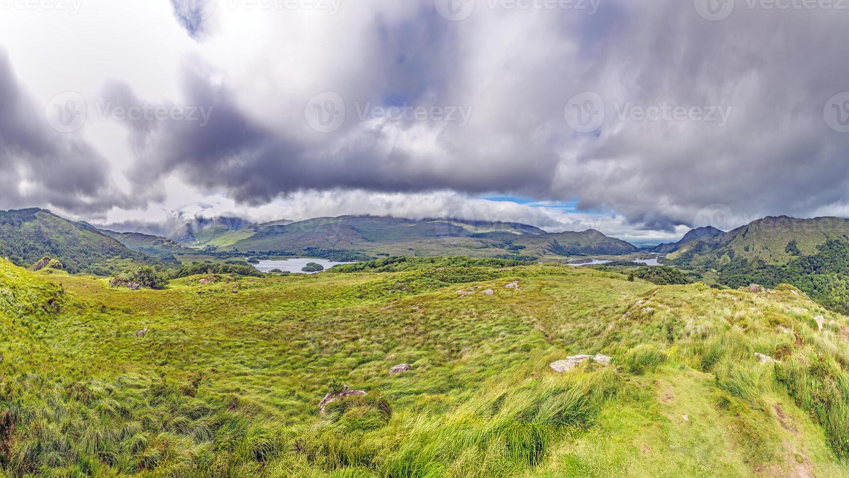 Scenic panorama of Killarney National Park with lush green hills and dramatic clouds photo