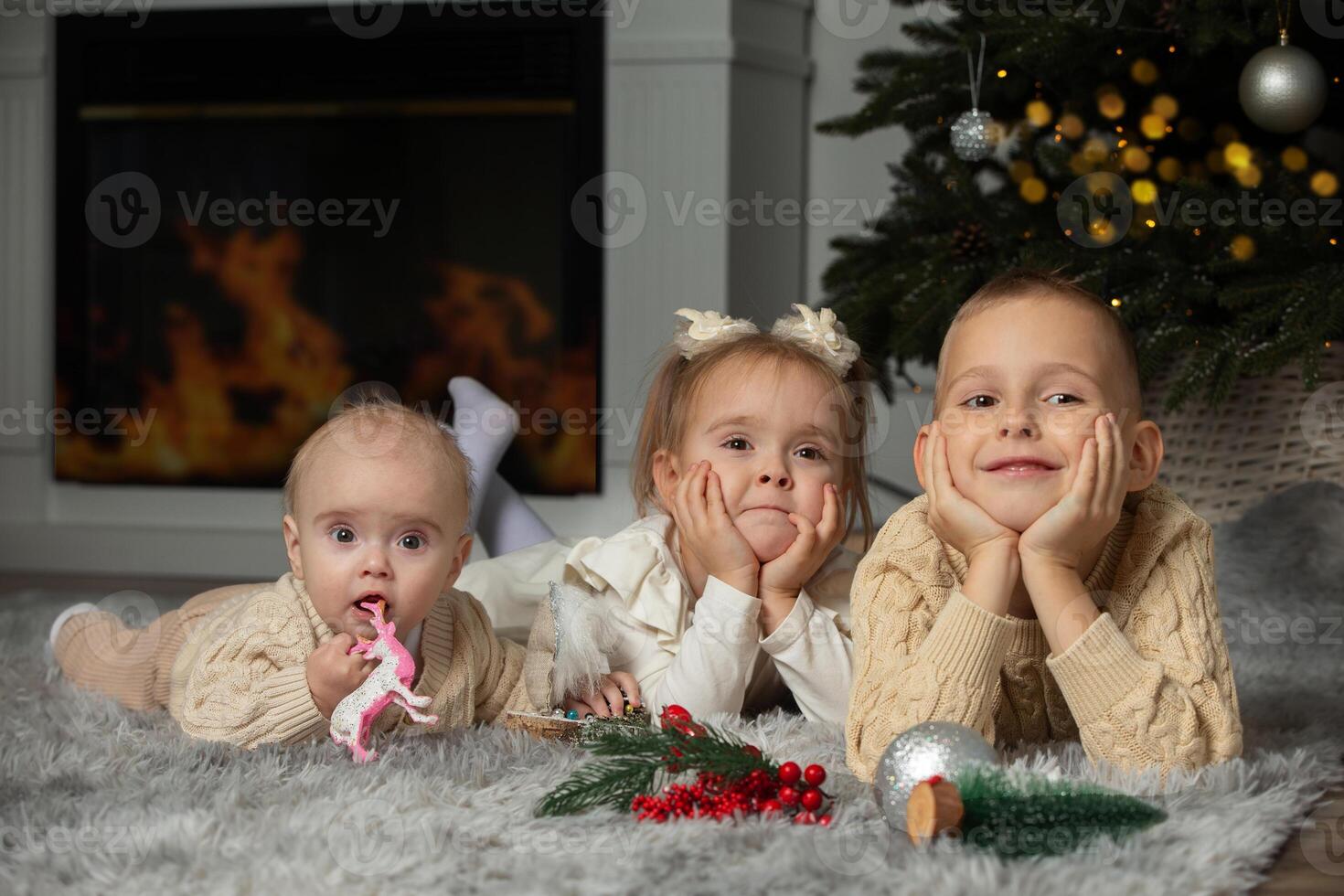 Overjoyed small children in santa hats have fun unpack wrapped presents on merry Christmas morning near fir tree. photo