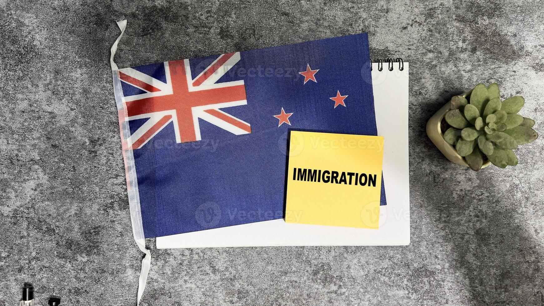 Concept of Immigration write on sticky notes and Flag of the Australia isolated on Wooden Table. photo
