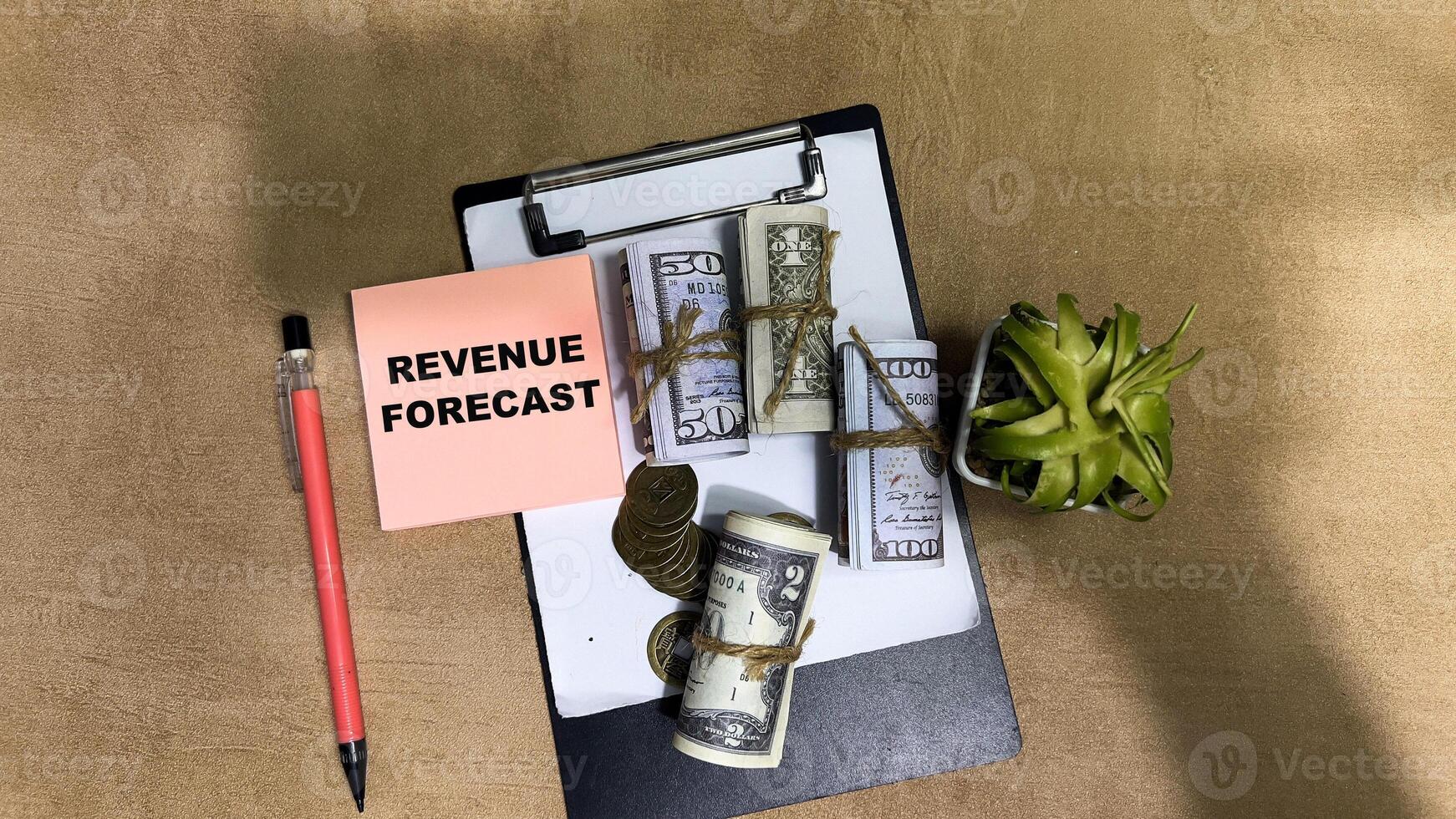 Concept of Revenue Forecast write on sticky notes isolated on Wooden Table. photo