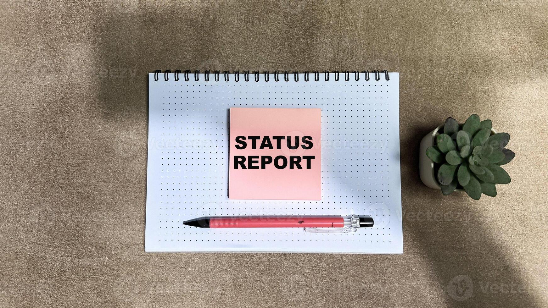 Concept of Status Report write on sticky notes isolated on Wooden Table photo