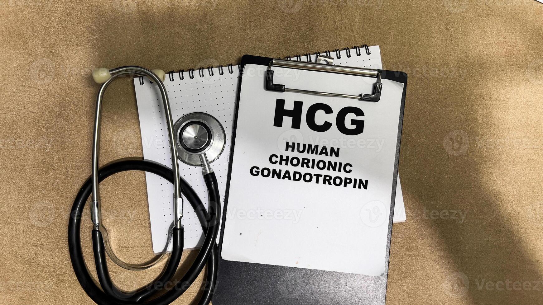 Concept of HCG - Human Chorionic Gonadotropin write on paperwork isolated on Wooden Table. photo