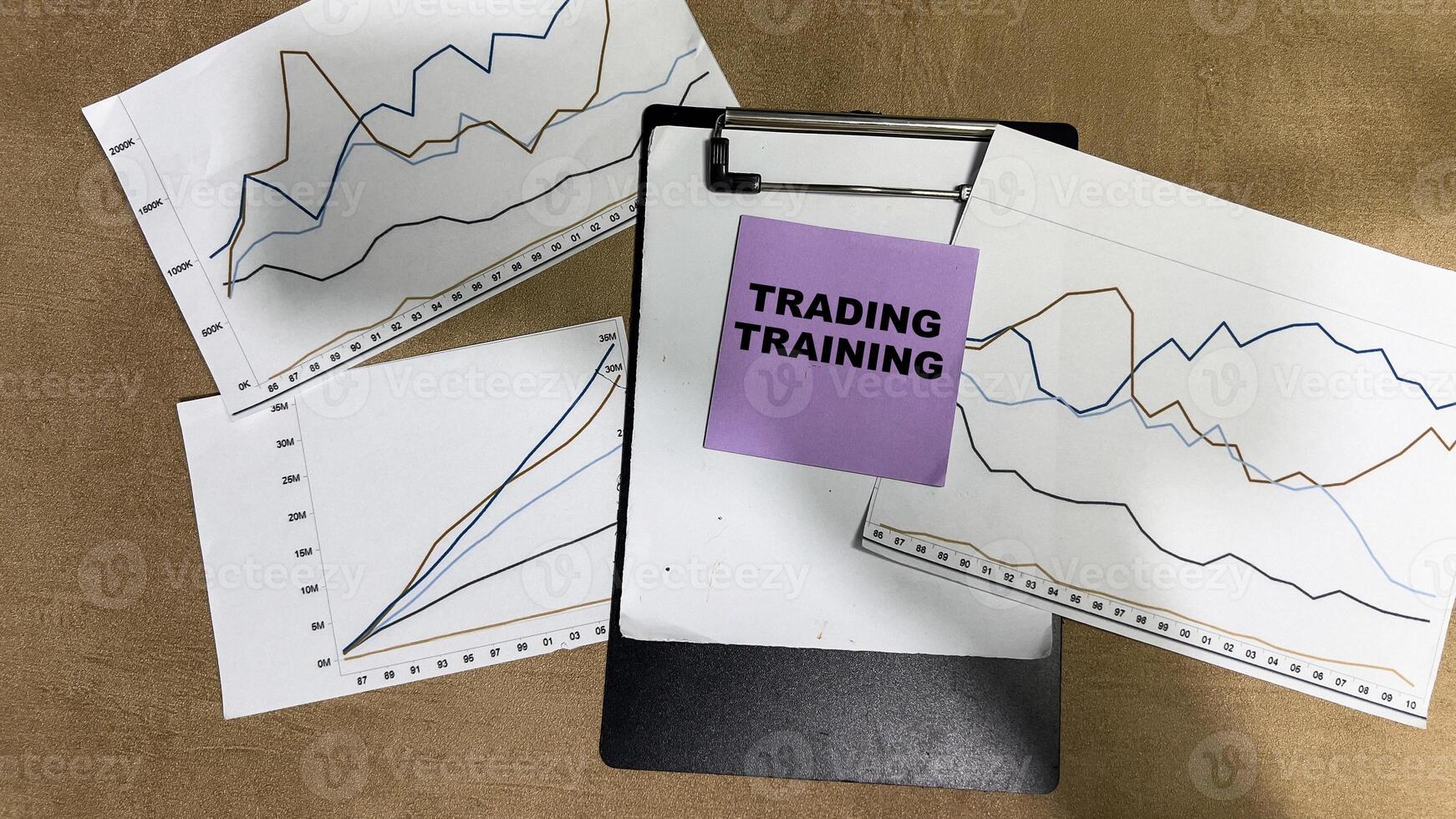 Concept of Trading Training write on sticky notes isolated on Wooden Table. photo