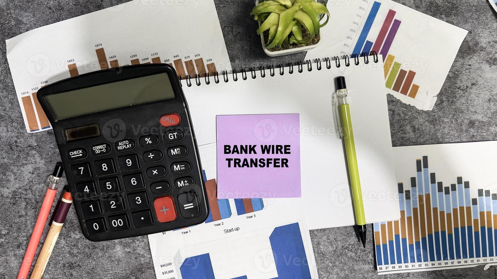 Concept of Bank Wire Transfer write on sticky notes isolated on Wooden Table. photo