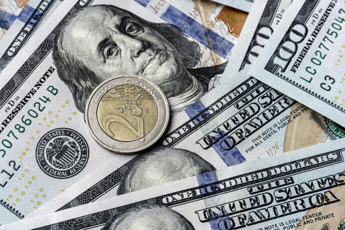 A one dollar coin is sitting on top of a pile of us dollars photo