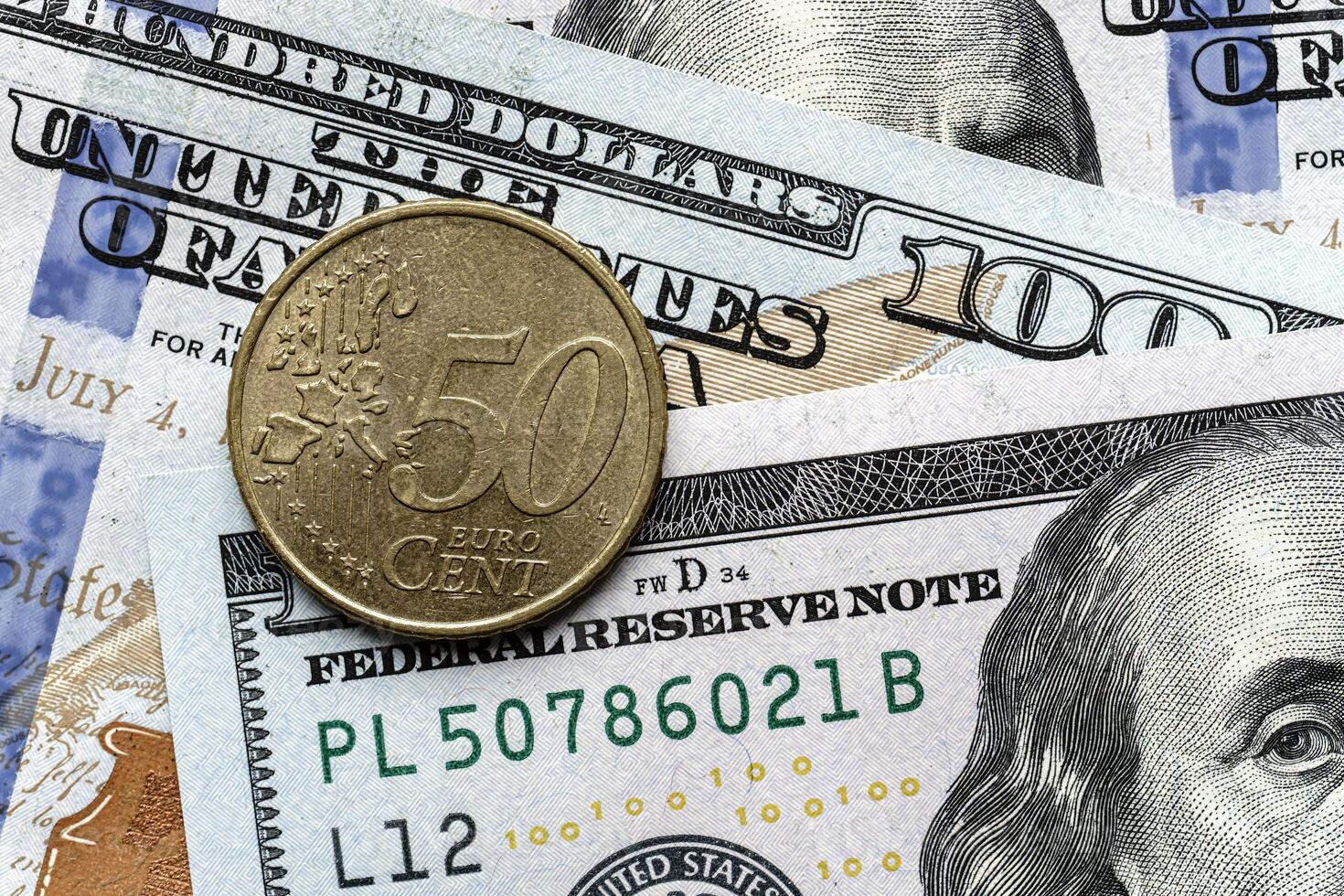 A one dollar coin is sitting on top of a pile of us dollars photo