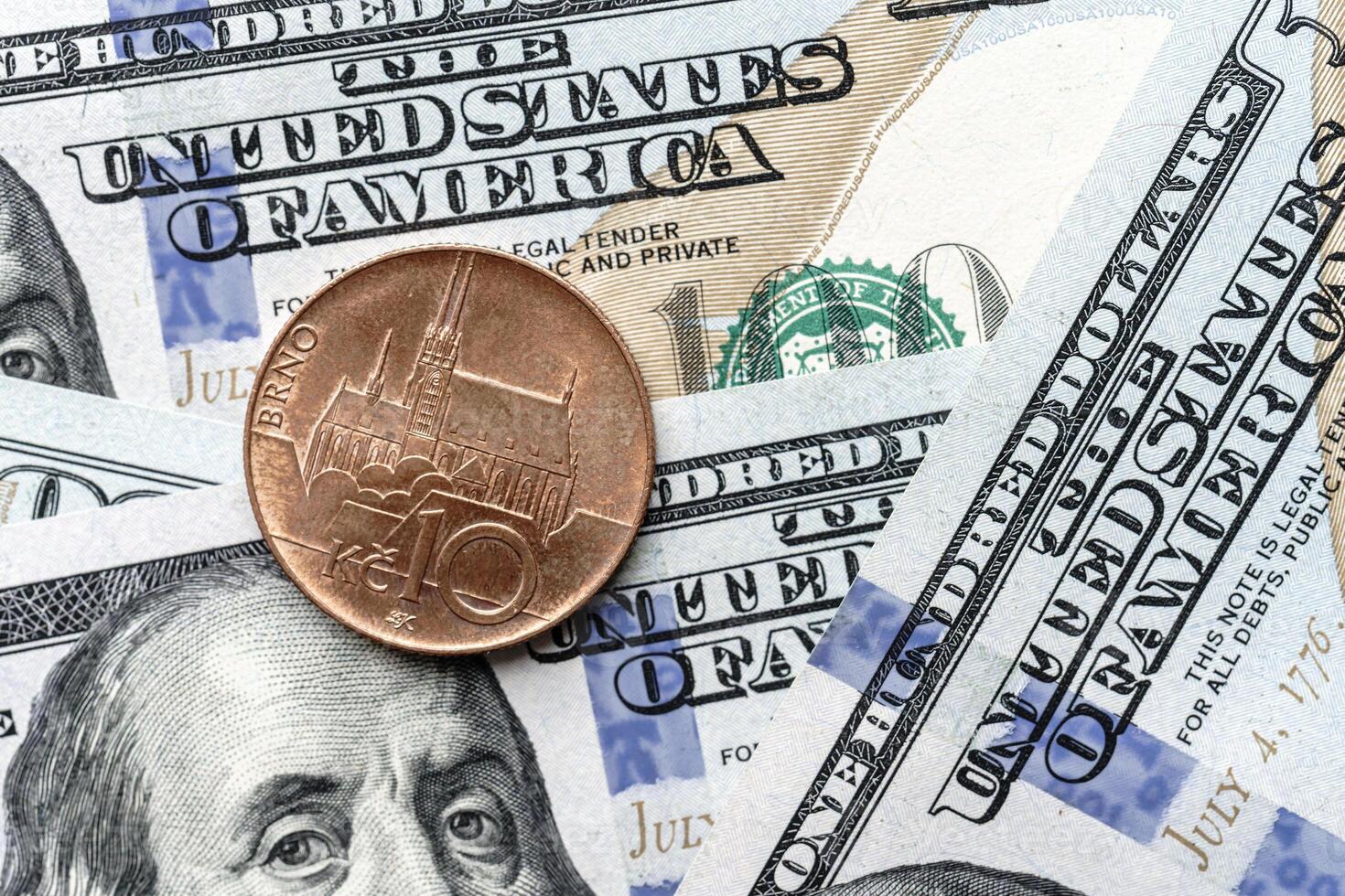 A one cent coin is sitting on top of a pile of us dollars photo