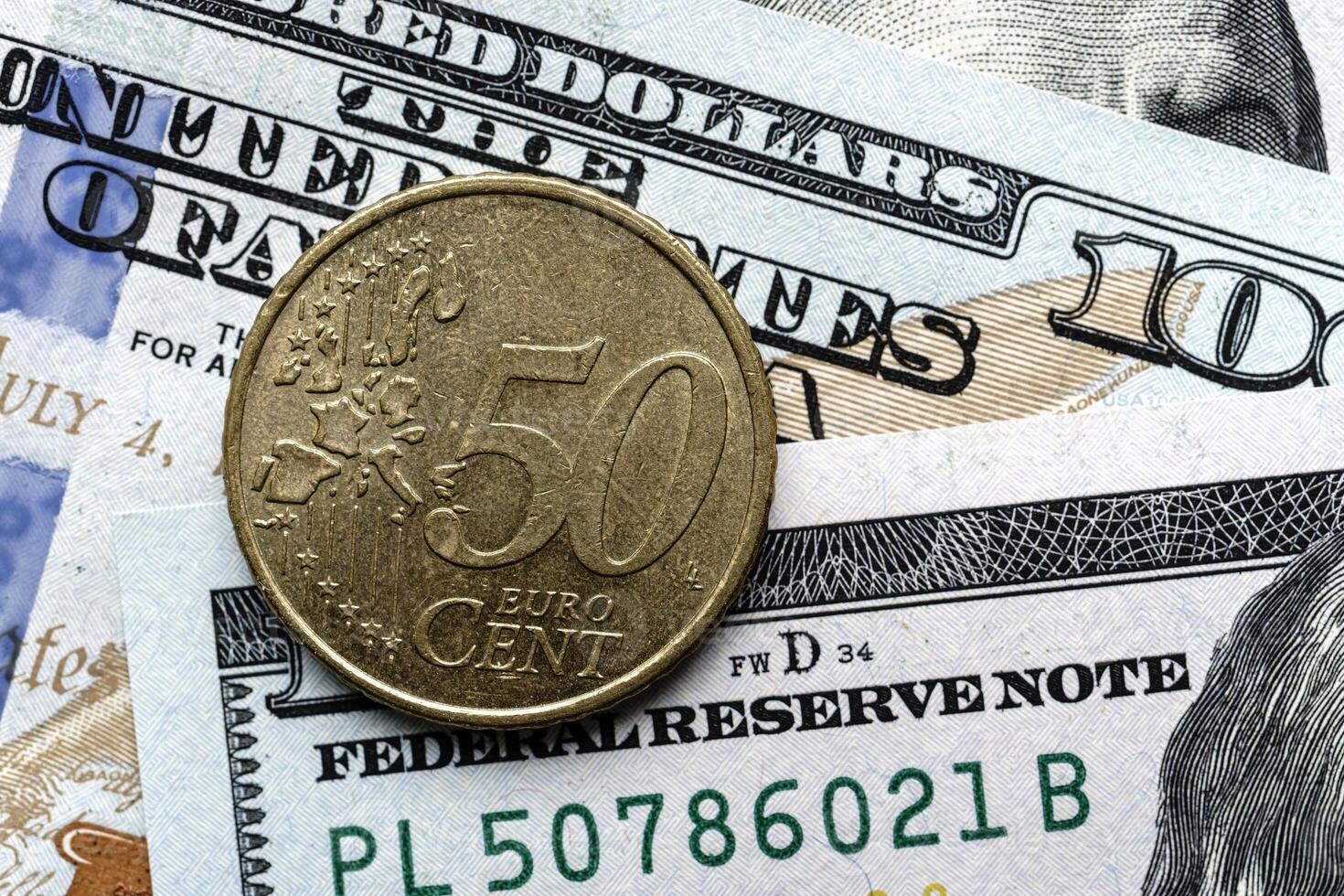 A euro coin is sitting on top of a pile of money photo