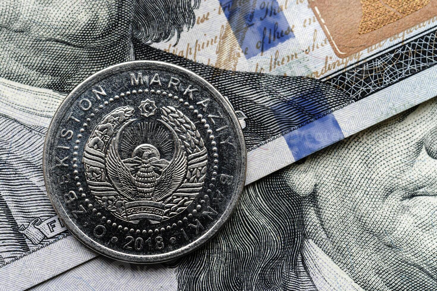 A coin is sitting on top of a stack of money photo