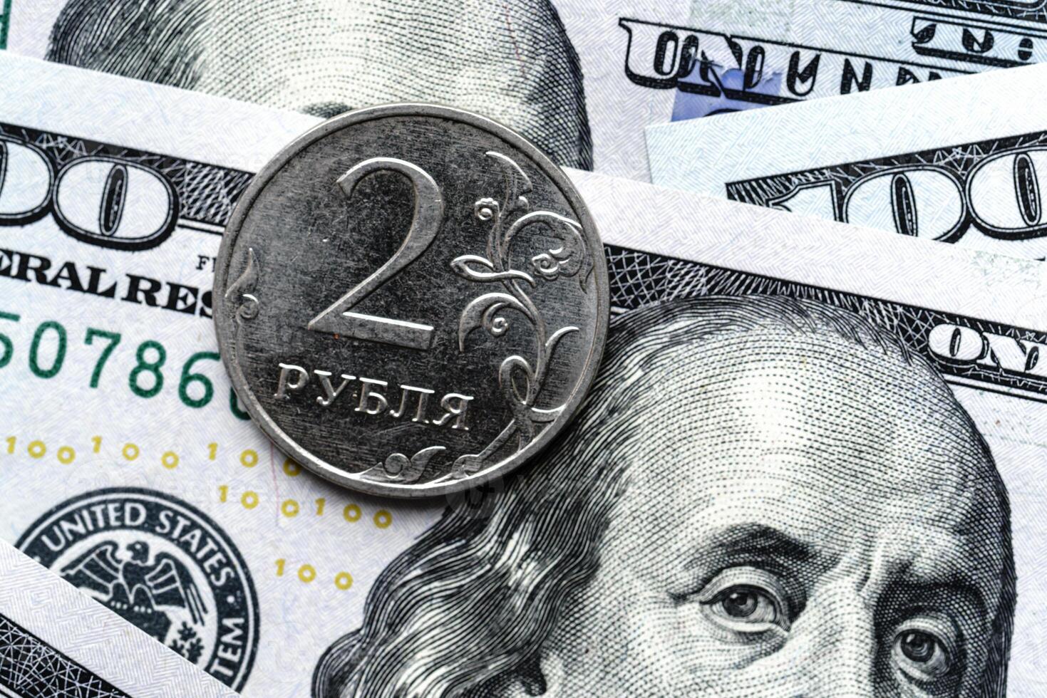 A close up of a russian coin and a hundred dollar bill photo