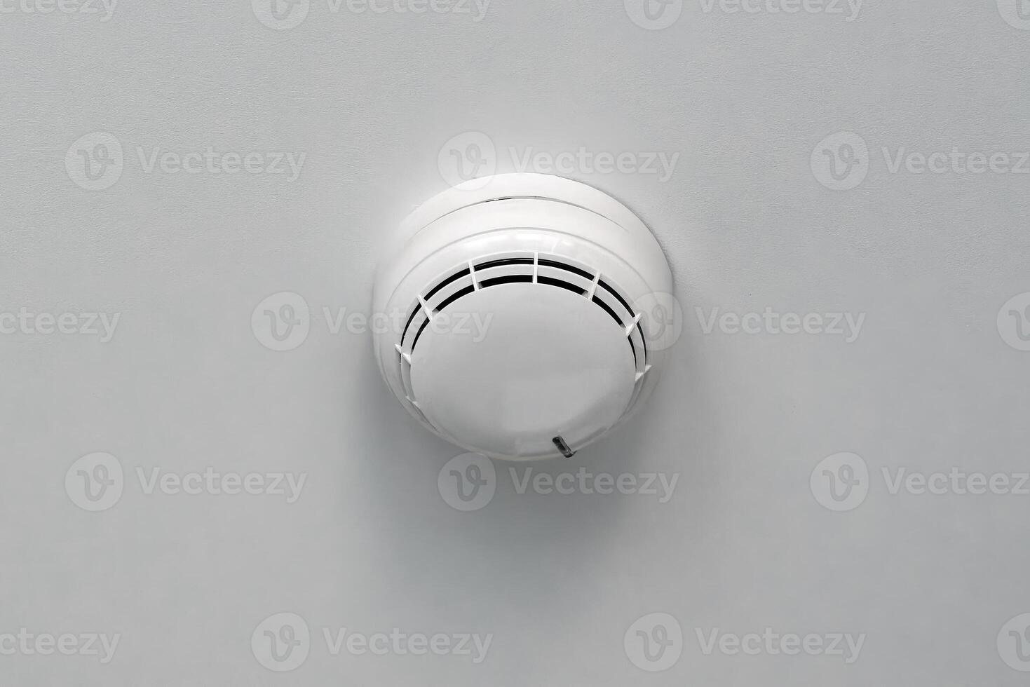 A white smoke detector on a wall photo