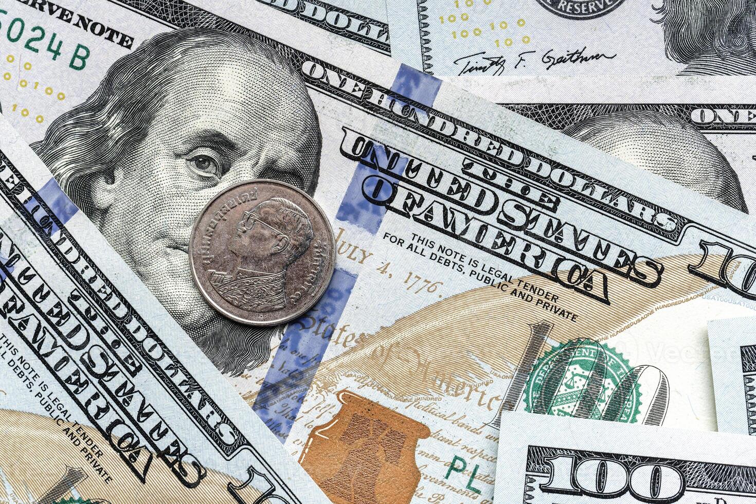 A close up of a hundred dollar bill with a coin photo