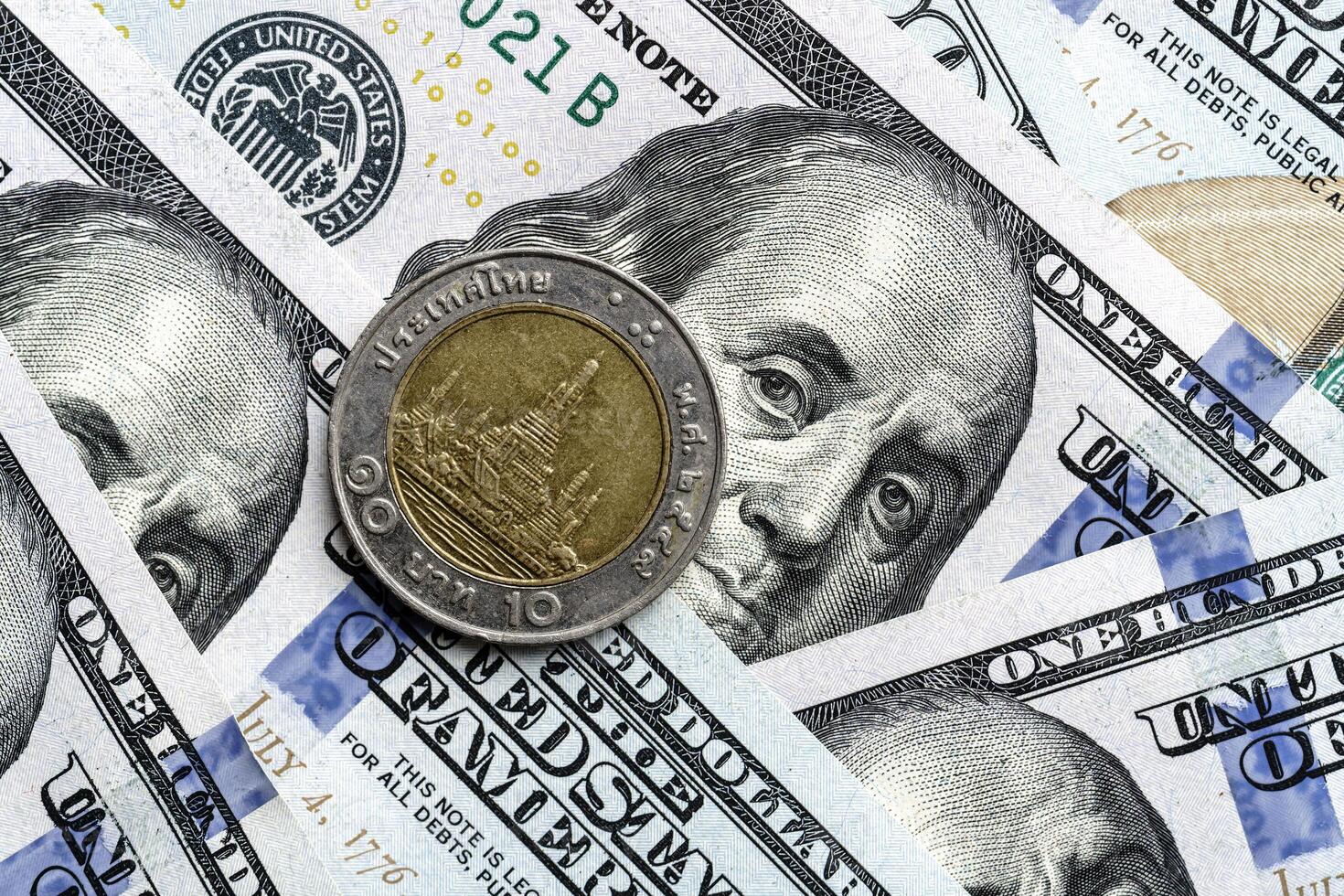 A one dollar coin is sitting on top of a pile of us dollars photo