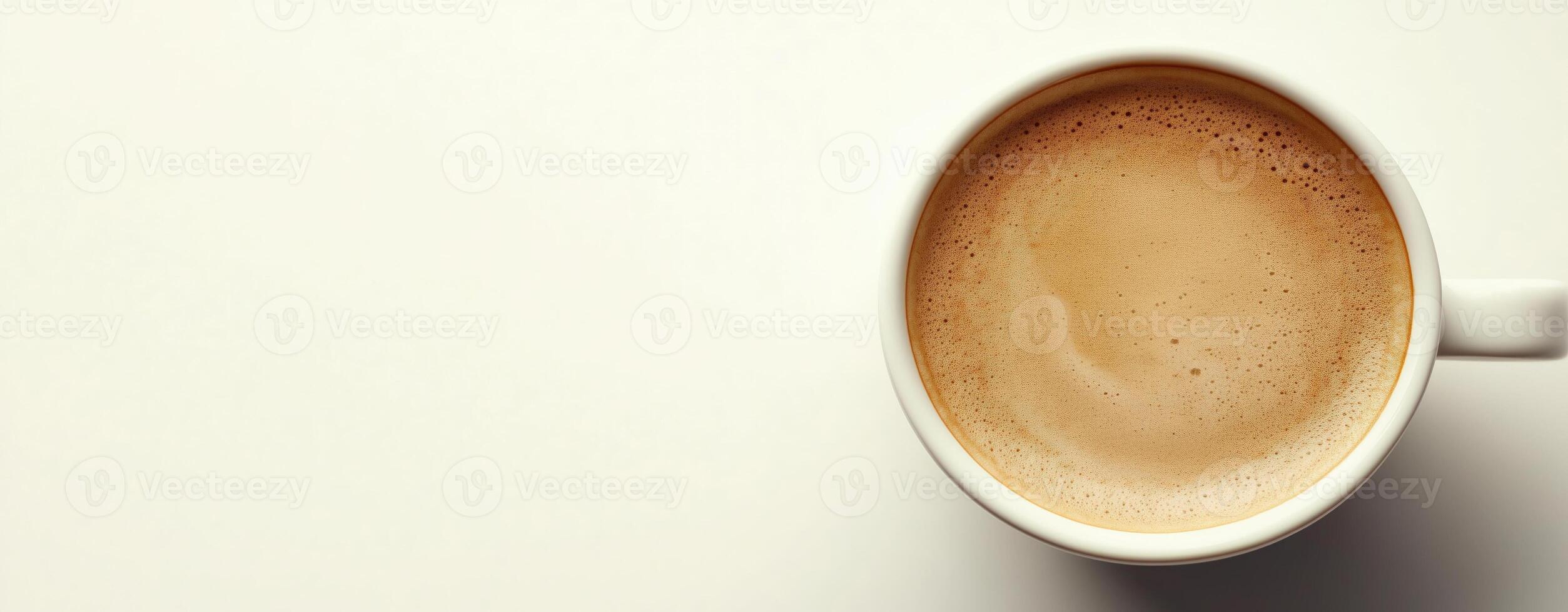 Top view of a cup filled with frothy cappuccino on a white background, copy space photo