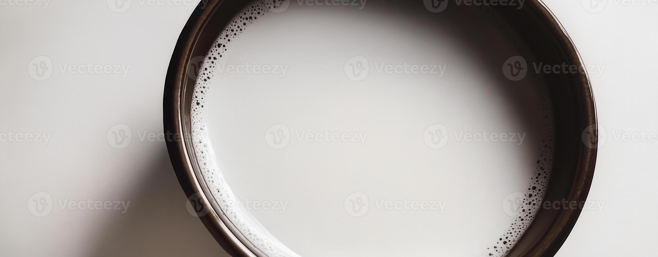 Minimalist close-up of a bowl filled with milk. Top view a cup of milk, white background photo