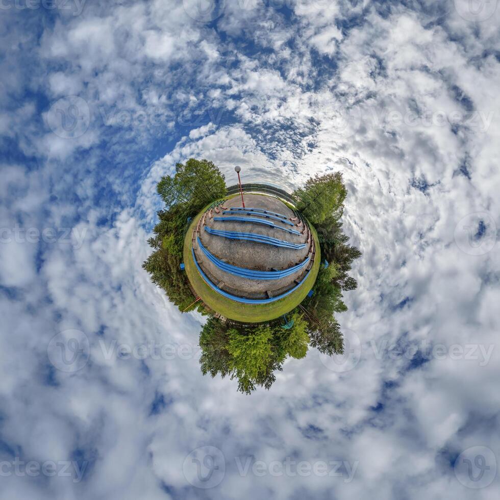 A small planet with a blue bench in the middle photo