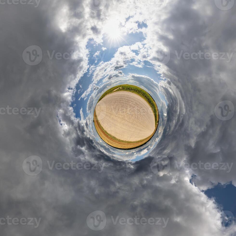 A circular view of a field with clouds and sun photo