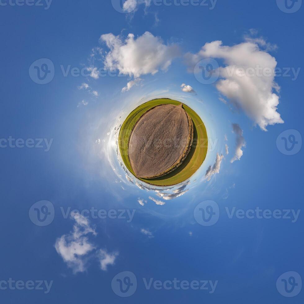 A small planet with a field and clouds photo