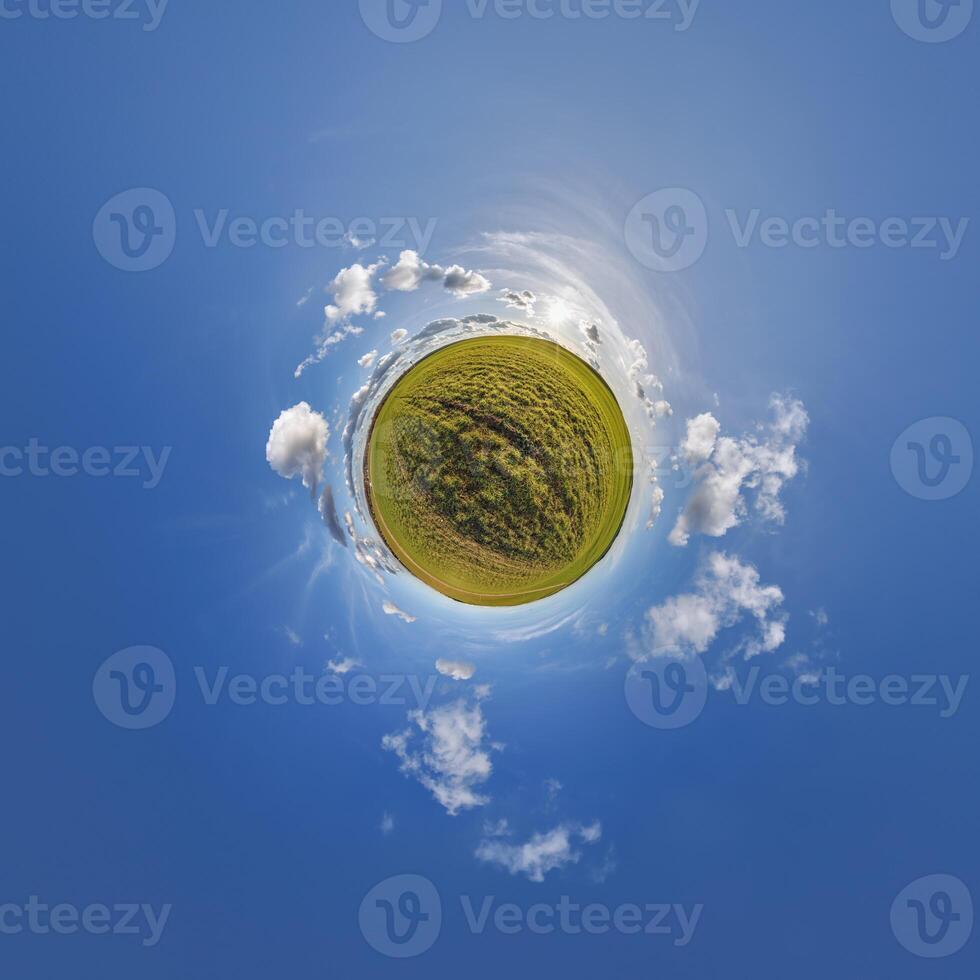 A small planet with a grassy field and clouds photo