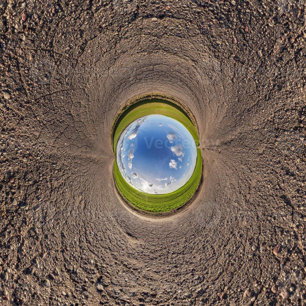 A circular hole in the ground with a blue sky photo