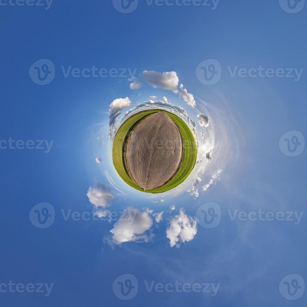 A small planet with a dirt road and clouds photo