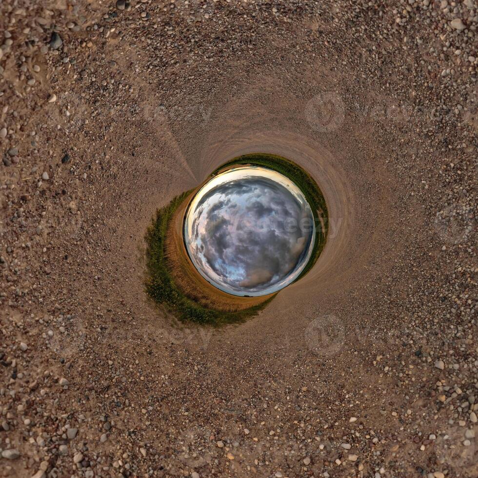 A circular hole in the ground with a blue sky photo