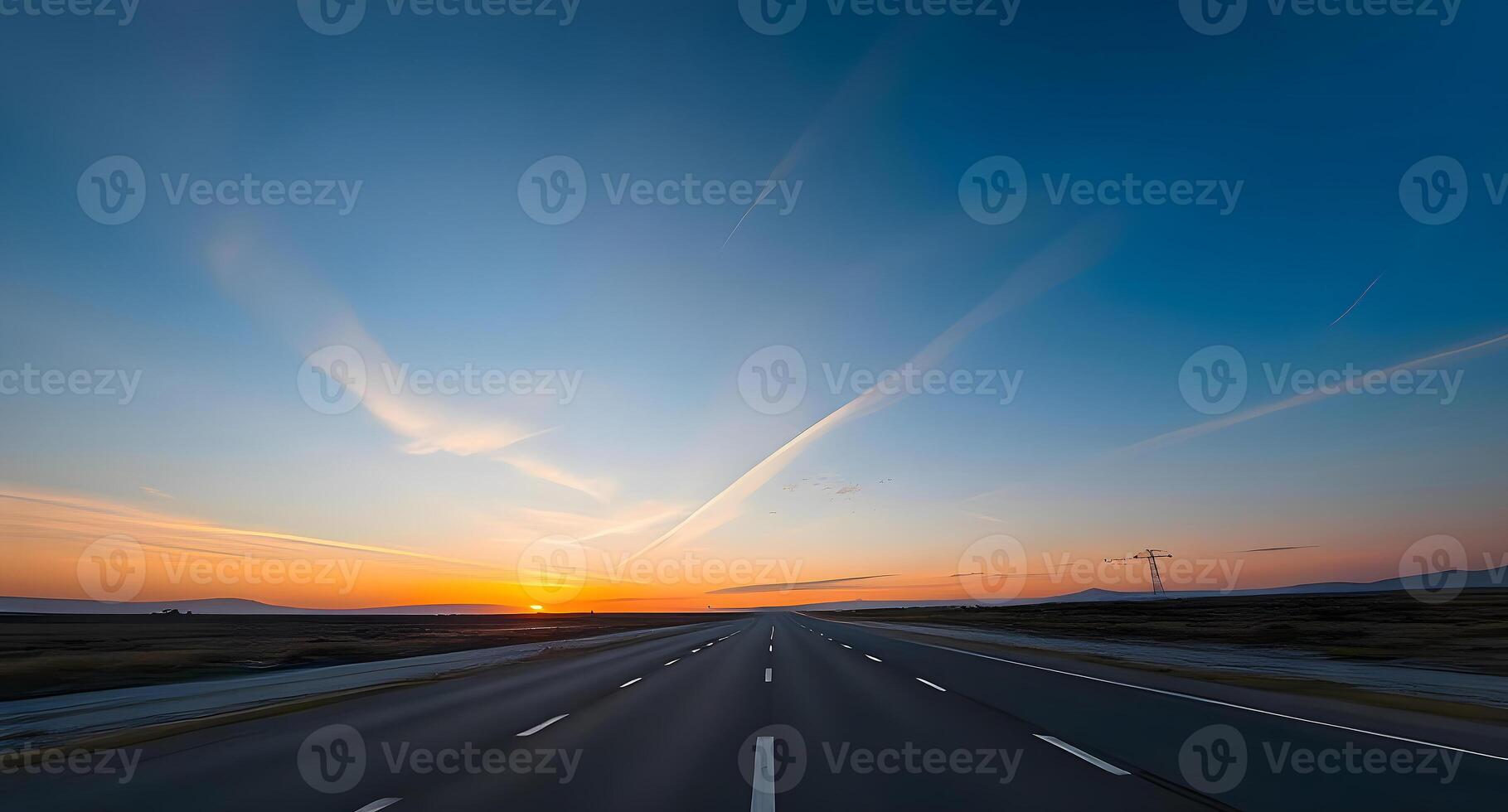 A highway with the sun setting in the distance photo