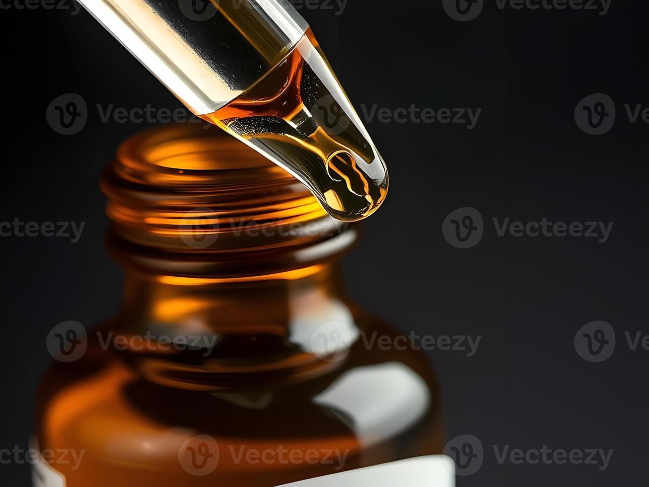 A dropper is pouring liquid into a bottle of cbd oil photo