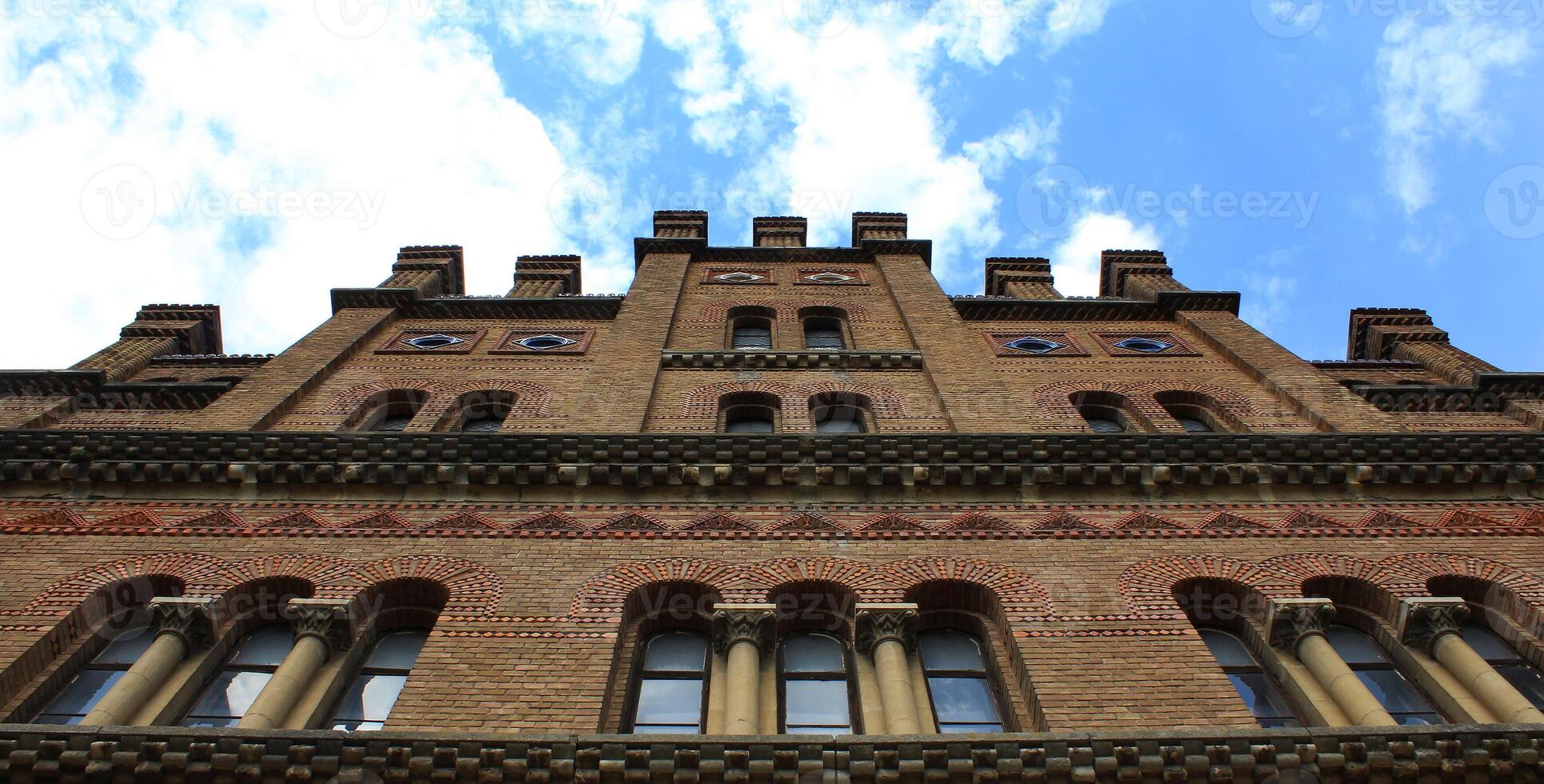 Facade Of Ancient Brick Castle Tower On Cloudy Sky Bottom View photo