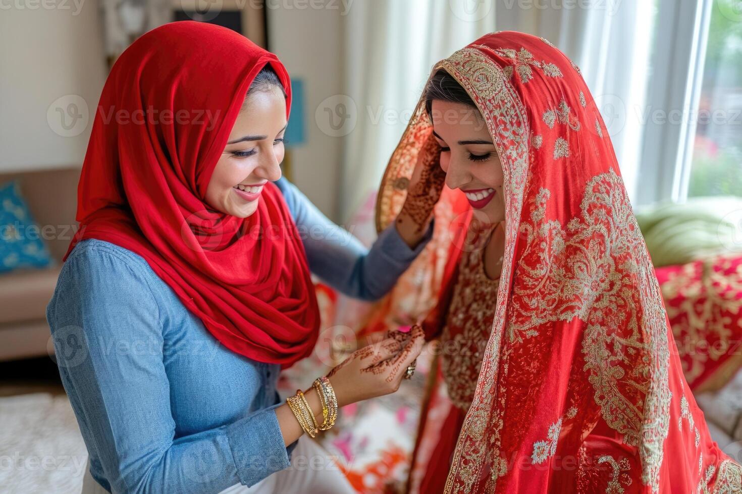 A bride in a red hijab is helping her friend put on her veil photo