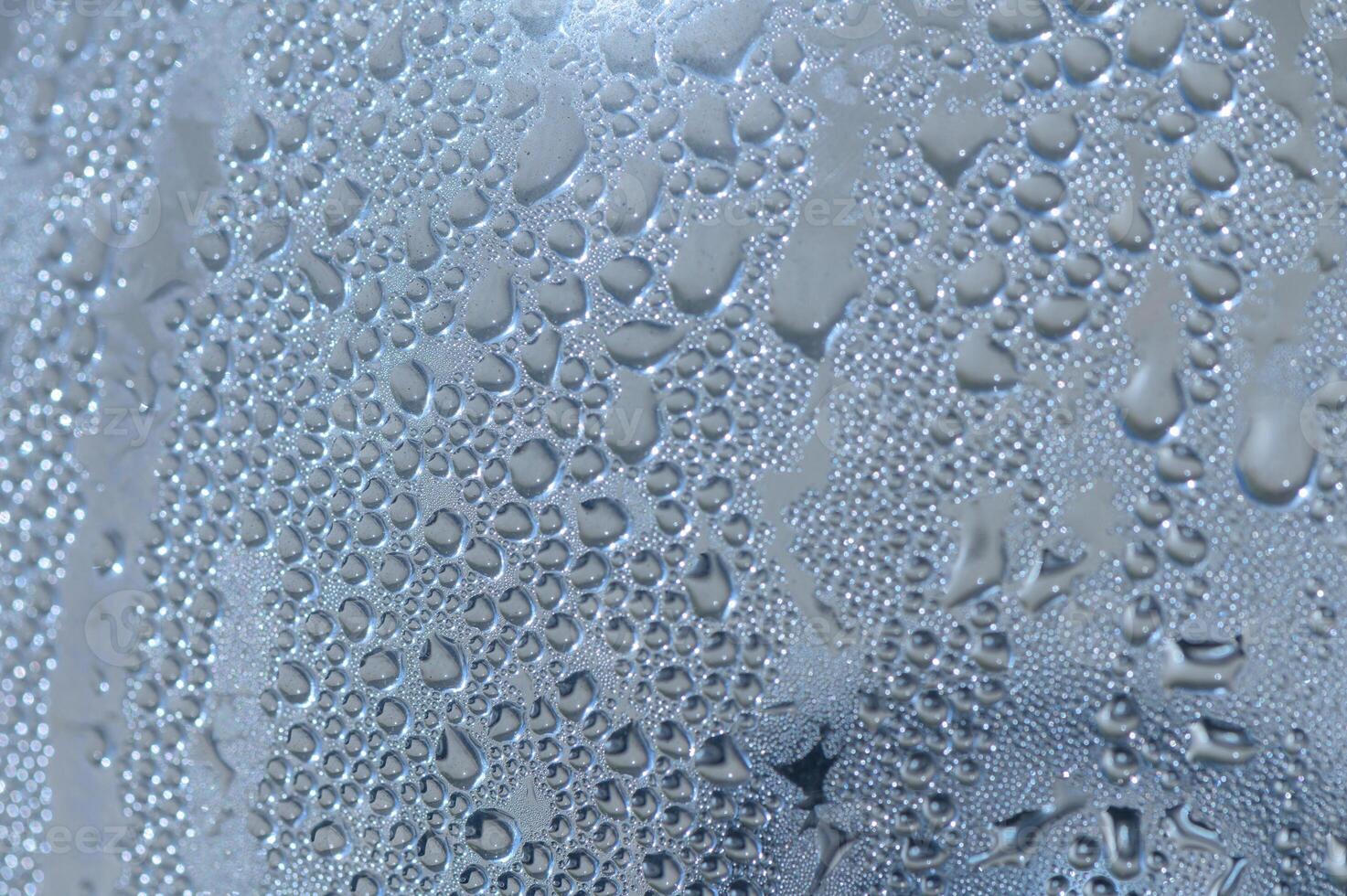 Water droplets cling to a surface after a refreshing rainfall illuminating delicate patterns photo