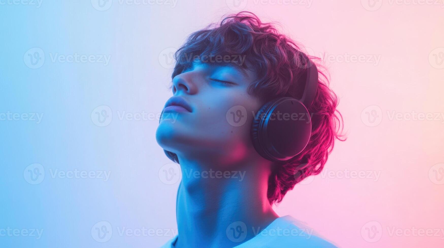 A young man wearing headphones and looking up photo