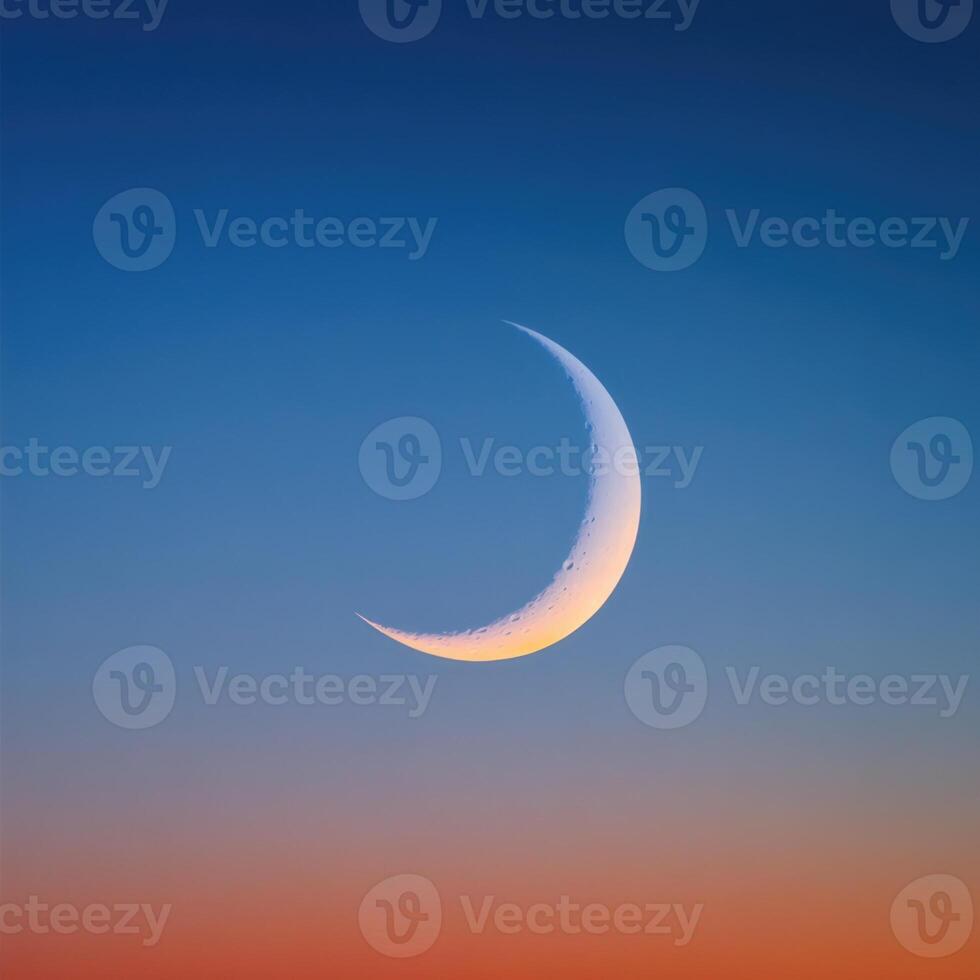 The crescent moon is seen in the sky at sunset photo