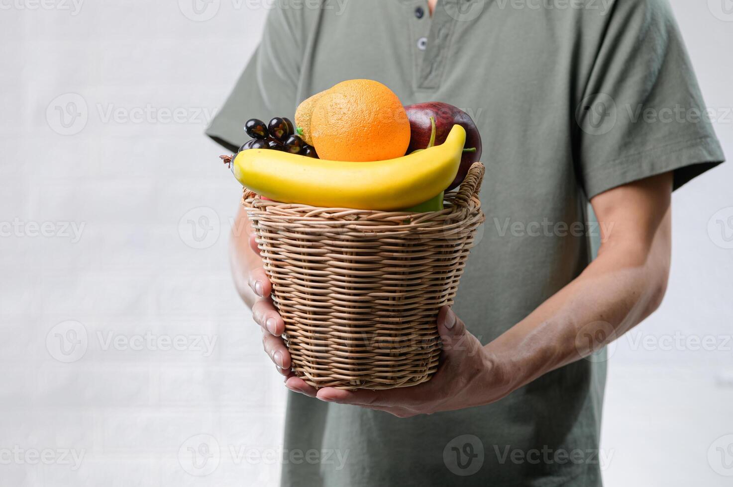 Fresh Fruits in Wicker Basket Held by Man in Gray Shirt photo