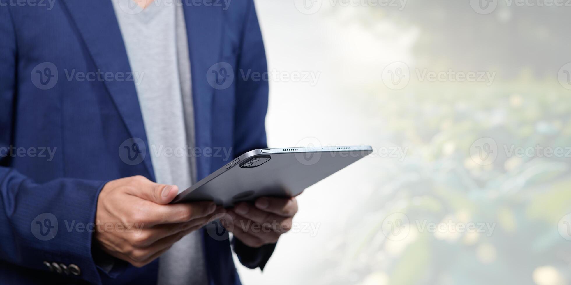 Businessman Using Tablet in Nature with Greenery Background photo