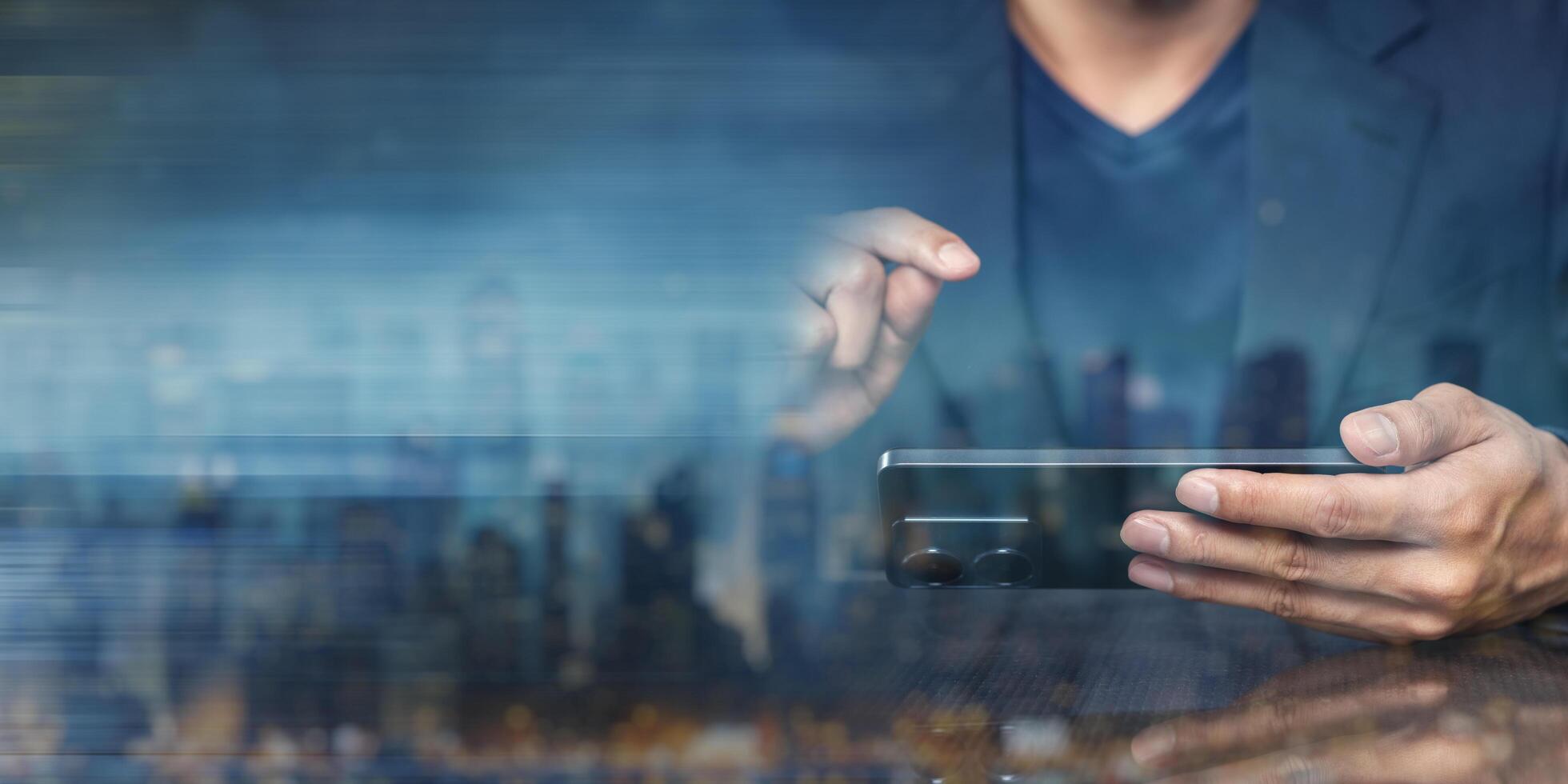 Man using smartphone with blurred cityscape background at night photo