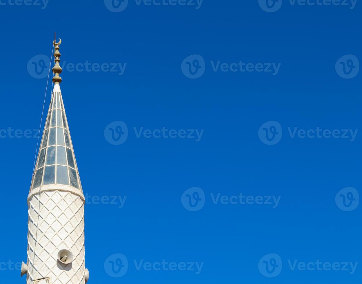 Mosque Minaret on a background of blue sky in Turkiye photo