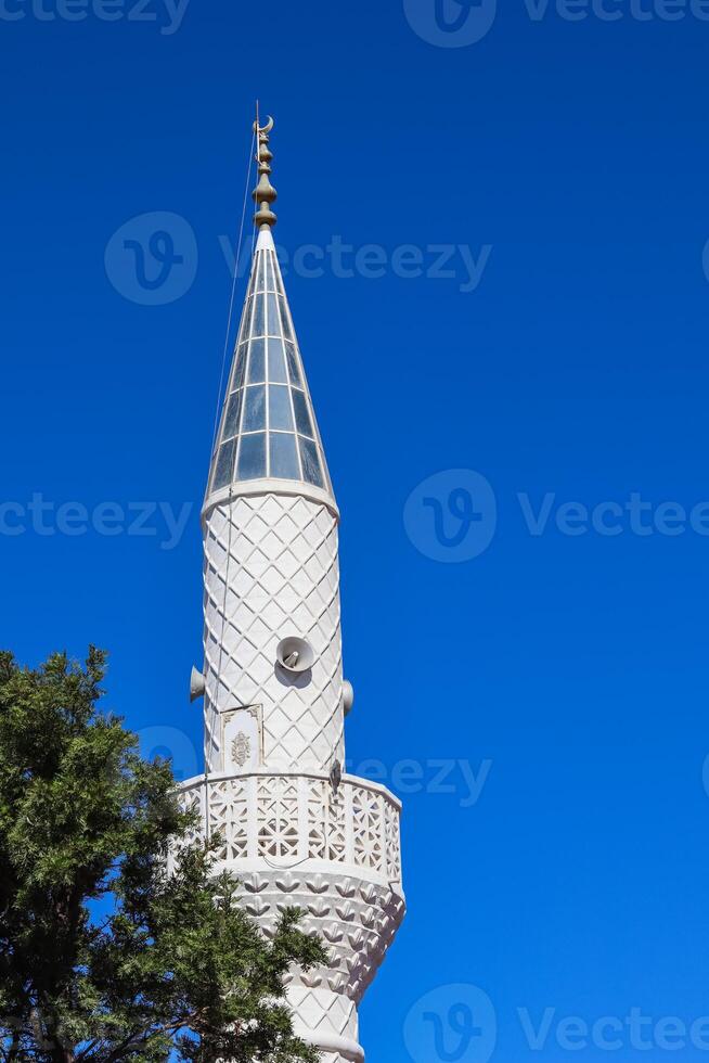 Mosque Minaret on a background of blue sky in Turkey photo