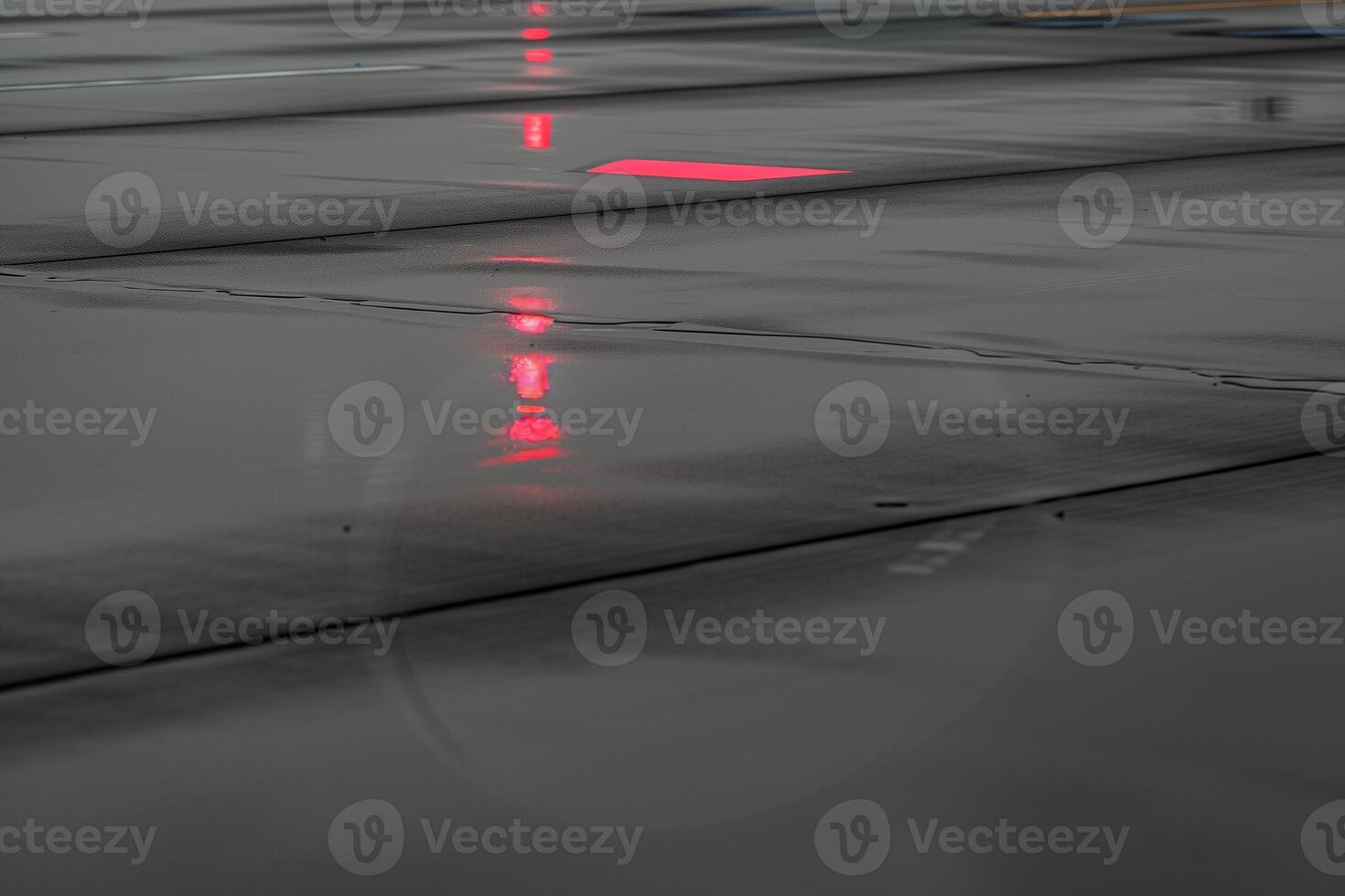 Jet nose reflected in rain-soaked runway with monochrome tones and red navigation light photo