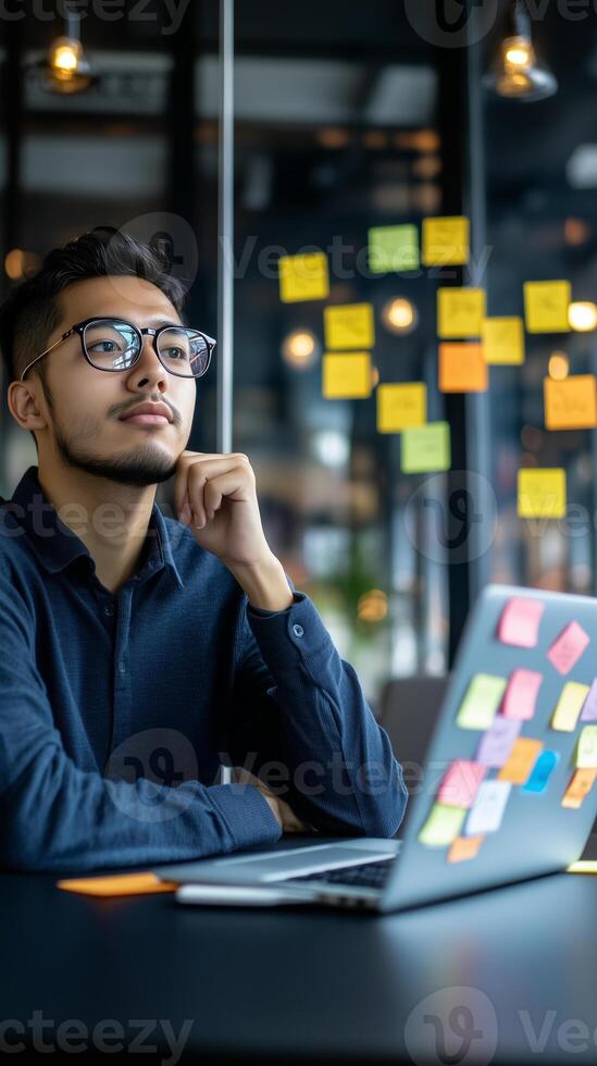 Stylish young software developer reflects on ideas in a modern co-working space filled with natural light photo