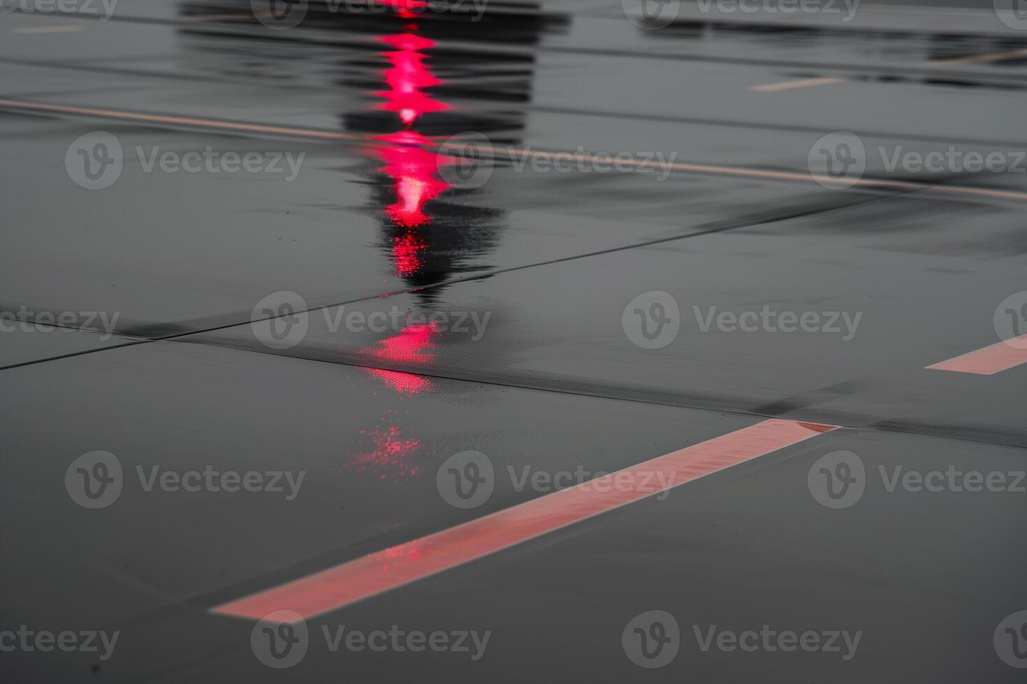 Jet nose reflection on a rain-soaked runway with red navigation light accent photo
