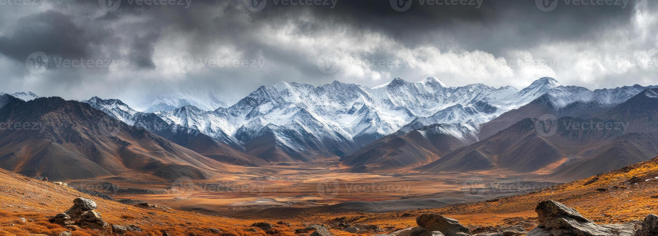 Snow-Capped Mountain Range Under Dramatic Clouds photo