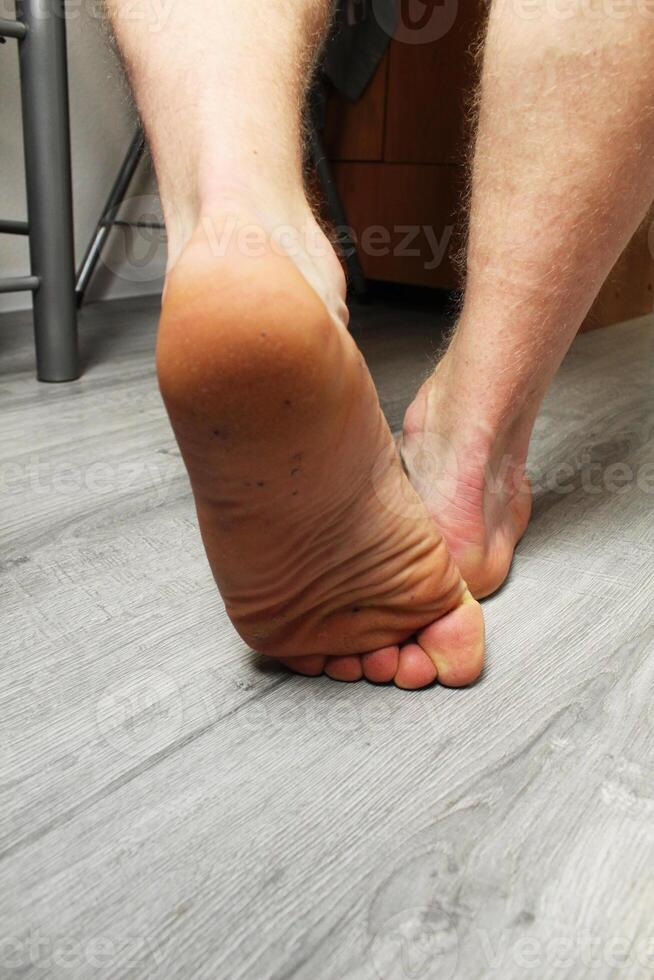 The heel of a man's left foot on a gray background. Vertical Photo