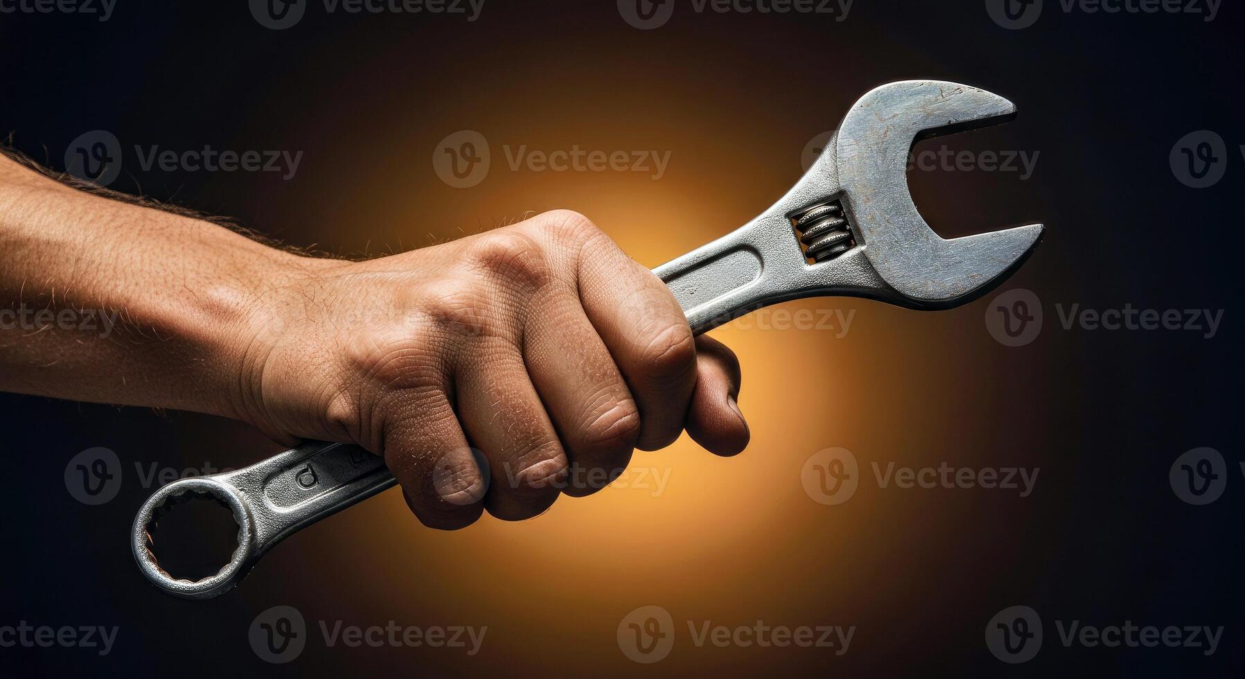 A hand holding a wrench on a dark background photo